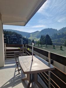 a table on a balcony with a view of the mountains at La Bresse OURSON in La Bresse