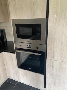 a microwave oven in the corner of a kitchen at Villa Angelina in De Panne