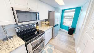 a kitchen with a stove and a refrigerator at SeaCrest 306 in Fort Walton Beach +38 photos