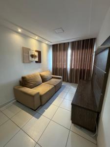 a living room with a couch and a television at Apartamento Caruaru in Caruaru