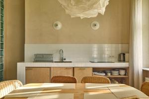 a kitchen with a table and chairs and a counter at ŻAR - Dworek w Żarnowcu in Żarnowiec