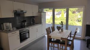 a kitchen with a table and a dining room at Pension zur Schmiede in Einruhr