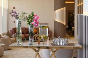 a table with two vases with flowers on it at Riyadh Inn Hotel in Riyadh