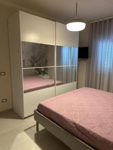 a bedroom with a pink bed and a cabinet at Profumi di Sicilia House in Villaggio Mosè +16 photos