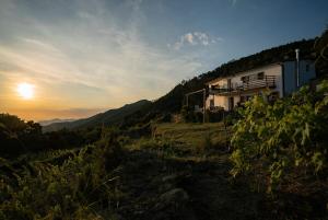 una casa en una colina con la puesta de sol en el fondo en Rifugio Cinque Terre, en Biassa