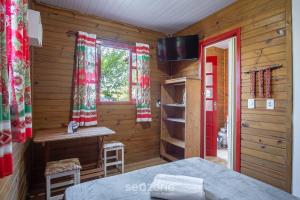 Μια τηλεόραση ή/και κέντρο ψυχαγωγίας στο Cabanas relaxantes perto da Praia do Rosa - PRJ