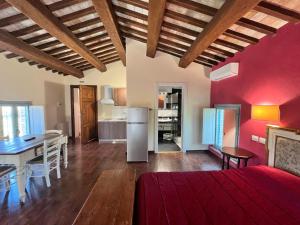 a living room with red walls and a table and a kitchen at Casale San Francesco d'Assisi in Assisi