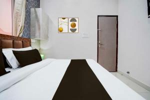 a bedroom with a bed with a black and white blanket at Townhouse Oak Vasundra Nagar in Rajod