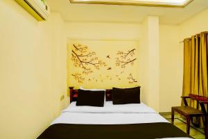 Un dormitorio con una cama y un cuadro en la pared. en Townhouse Oak Ranthambore Road, en Sawāi Mādhopur
