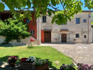 an external view of a building with flowers in a yard at Casale San Francesco d'Assisi in Assisi