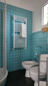 Un baño con azulejos azules, inodoro y lavabo. en Rifugio Cinque Terre, en Biassa
