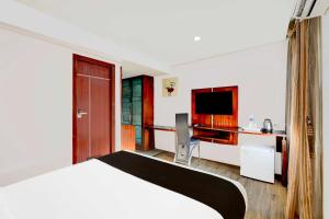 a hotel room with a bed and a desk at Townhouse Oak Pondicherry Opposite to Rock Beach in Puducherry