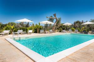a swimming pool with chairs and umbrellas at Tenuta San Lorenzo in Otranto