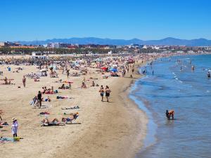 una spiaggia affollata con un sacco di gente sopra di Ayora Penthouse - Jacuzzi, Huge Private Rooftop, BBQ, Sunset Views, FastWifi, AC a Valencia