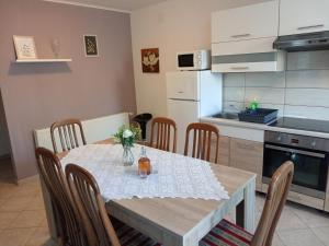 a dining room with a table and chairs in a kitchen at Apartmani Tomljenović in Senj