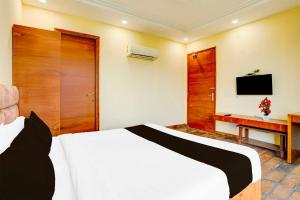 a hotel room with a bed and a television at Townhouse Oak Sector 47 Near Medanta in Gurgaon
