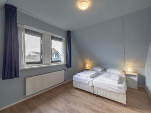 a bedroom with two beds and a window at Villa in Julianadorp near the Beach in Julianadorp