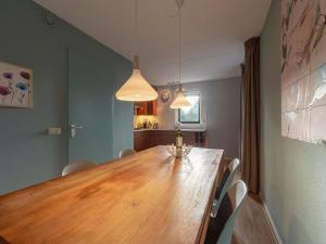a dining room with a large wooden table and chairs at Villa in Julianadorp near the Beach in Julianadorp