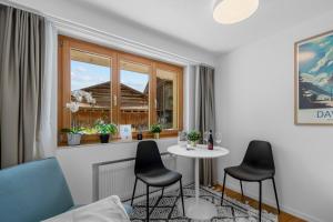 a living room with a table and chairs and a window at Gemütliche 1 Zimmer Wohnung in Davos Wiesen nähe der Skigebiete Davos in Wiesen