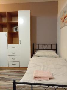 a bedroom with a bed with a pink towel on it at Apartmani Tomljenović in Senj