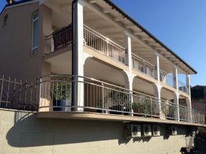 a building with a balcony with potted plants on it at Apartments Mirjana in Piran