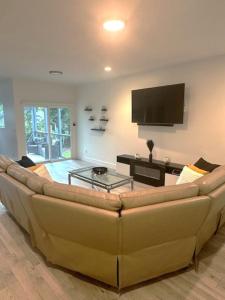 アトランタにあるPerfect Home in Perfect Locationのリビングルーム(大きなソファ、薄型テレビ付)