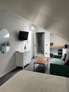 a living room with a couch and a tv at Izabelės apartamentai in Palanga