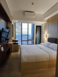 Postel nebo postele na pokoji v ubytování Pollux Habibie Suite City View By Superstay