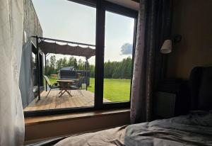 a bedroom with a window looking out onto a patio at Budas in Plieņciems