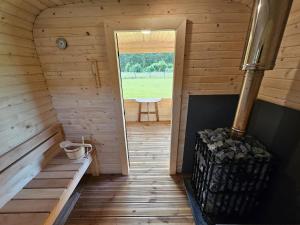 an inside view of a wooden cabin with a wood stove at Budas in Plieņciems
