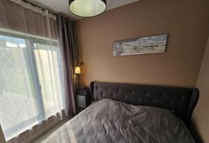 a bedroom with a bed next to a window at Budas in Plieņciems