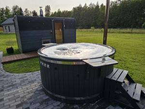 a hot tub in the middle of a yard at Budas in Plieņciems