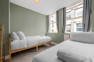 une chambre avec deux lits et une fenêtre dans l'établissement Iconic Canal Street Apt by City SuperHost, à Manchester