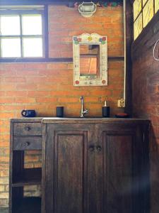Un baño con lavabo de madera y espejo. en Casa Pindorama - Chalé Opy, en Paraty