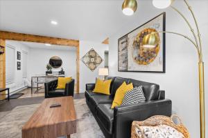 a living room with a black leather couch and yellow pillows at Relaxed 1BR Mountain Escape w Fireplace & Parking in Steamboat Springs