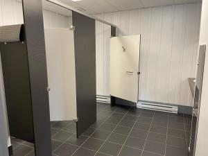 a locker room with two stalls and a mirror at Fort Ingall in Notre-Dame-du-Lac
