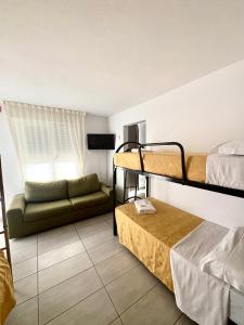 a room with two bunk beds and a couch at Appartamento Damma's in Cesenatico