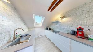 a kitchen with white cabinets and a sink and a window at Marktplatz Traunsee LAKE View in Gmunden