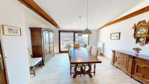 a dining room with a table and a clock on the wall at Marktplatz Traunsee LAKE View in Gmunden