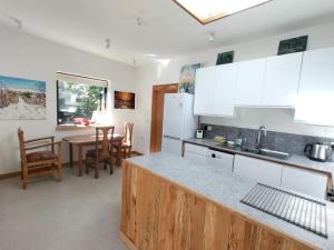 a kitchen with white cabinets and a table with chairs at Seadom House in Braunton