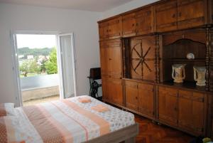 una camera da letto con un grande armadio in legno con un orologio di Ante Carov Apartment a Verunić