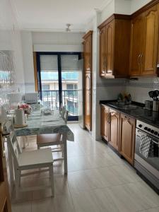 kuchnia ze stołem, krzesłami i kuchenką w obiekcie APARTAMENTO LA PERLA w mieście Portonovo