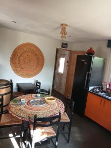 eine Küche mit einem Tisch und eine Küche mit einem Kühlschrank in der Unterkunft L'OAZIS de VALENCE in Malissard