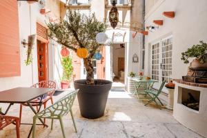 a courtyard with a table and a tree in a pot at Suite Bali - Ambiance zen et cocon secret in Carpentras