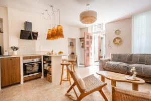 a kitchen and living room with a couch and a table at Suite Bali - Ambiance zen et cocon secret in Carpentras