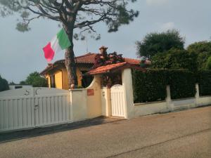 een huis met een wit hek en een vlag bij B&B La Casa di Rita in Castrezatto