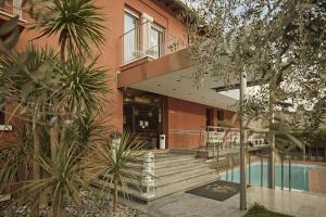 a building with a staircase and a swimming pool at Hotel Le Mura in Lazise