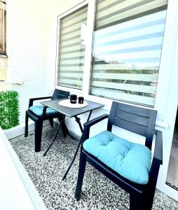 a patio with two chairs and a table on a balcony at Apartman Gold Jajce in Jajce +11 photos