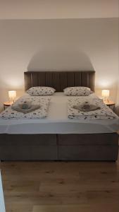 a bedroom with a bed with two lamps on it at Apartmani Silvana&Vera in Senj