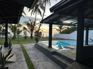 a house with a swimming pool with a view of the ocean at Tuktuk Cabanas in Negombo